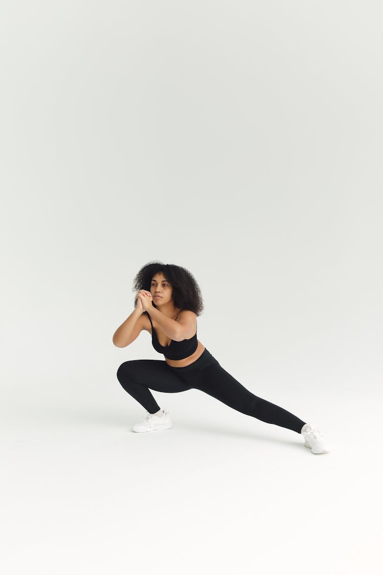 Woman Stretching Her Leg While Her Hands Together 