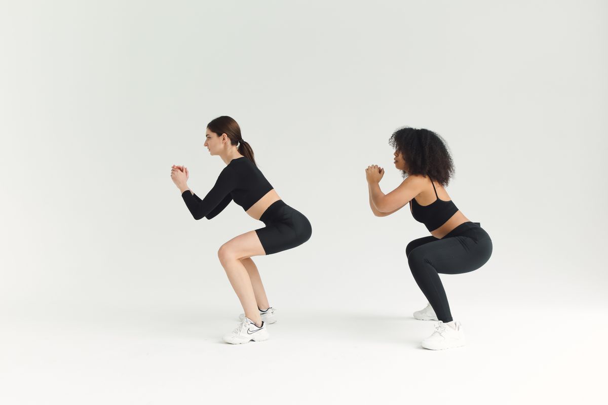 Women doing bodyweight squats together during a workout session