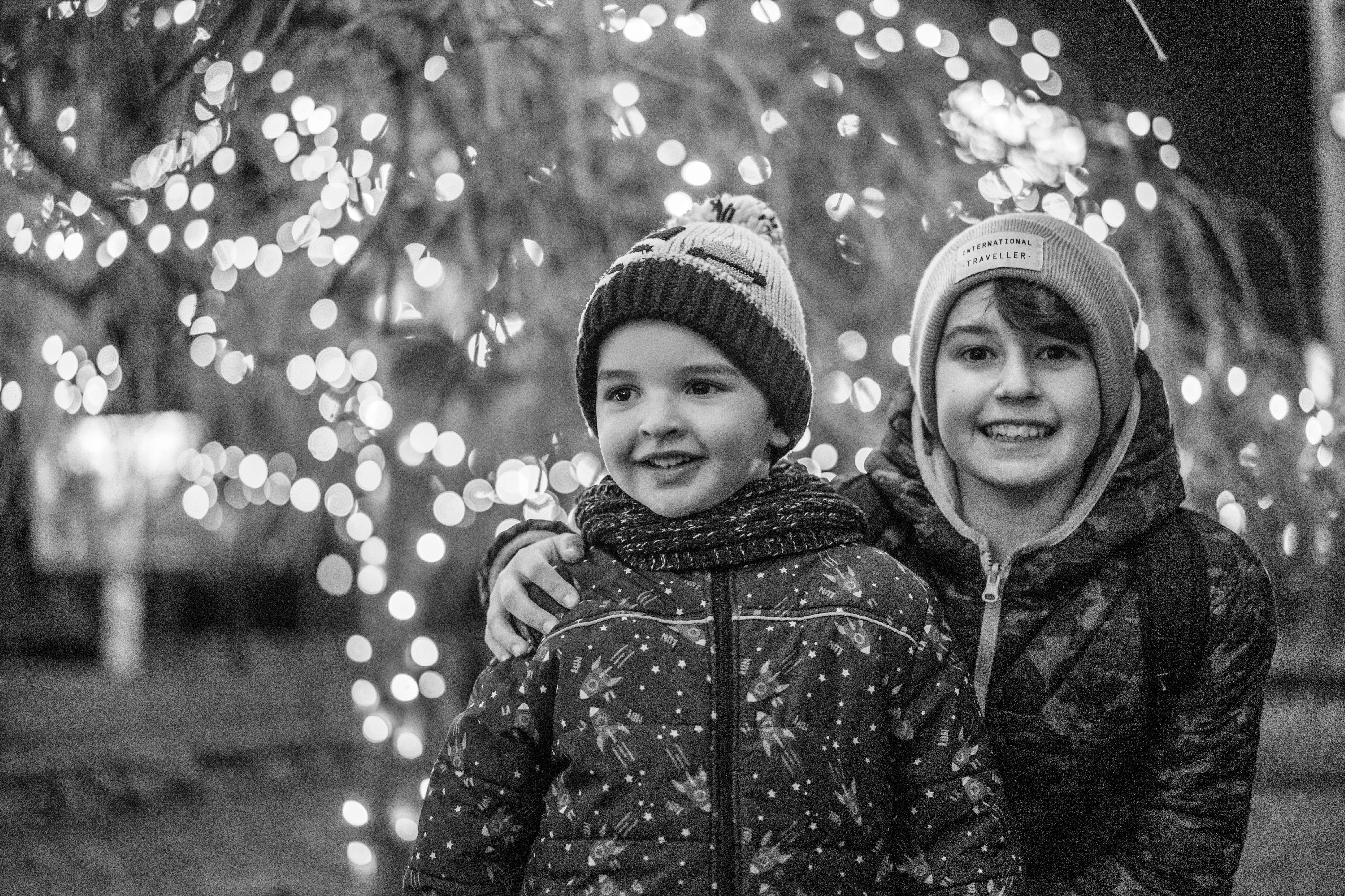 happy boys on street near illuminated trees