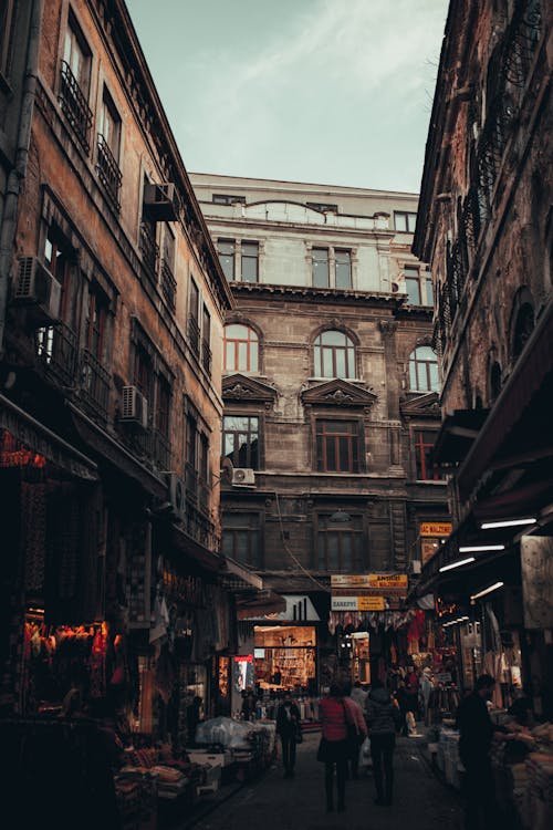 People Walking on Street Between Buildings