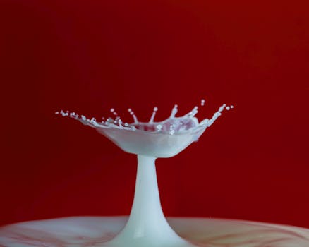 A mesmerizing capture of a milk splash resembling a crown on a vibrant red background.