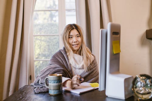 Free A Woman Having an Online Class Near a Window Stock Photo