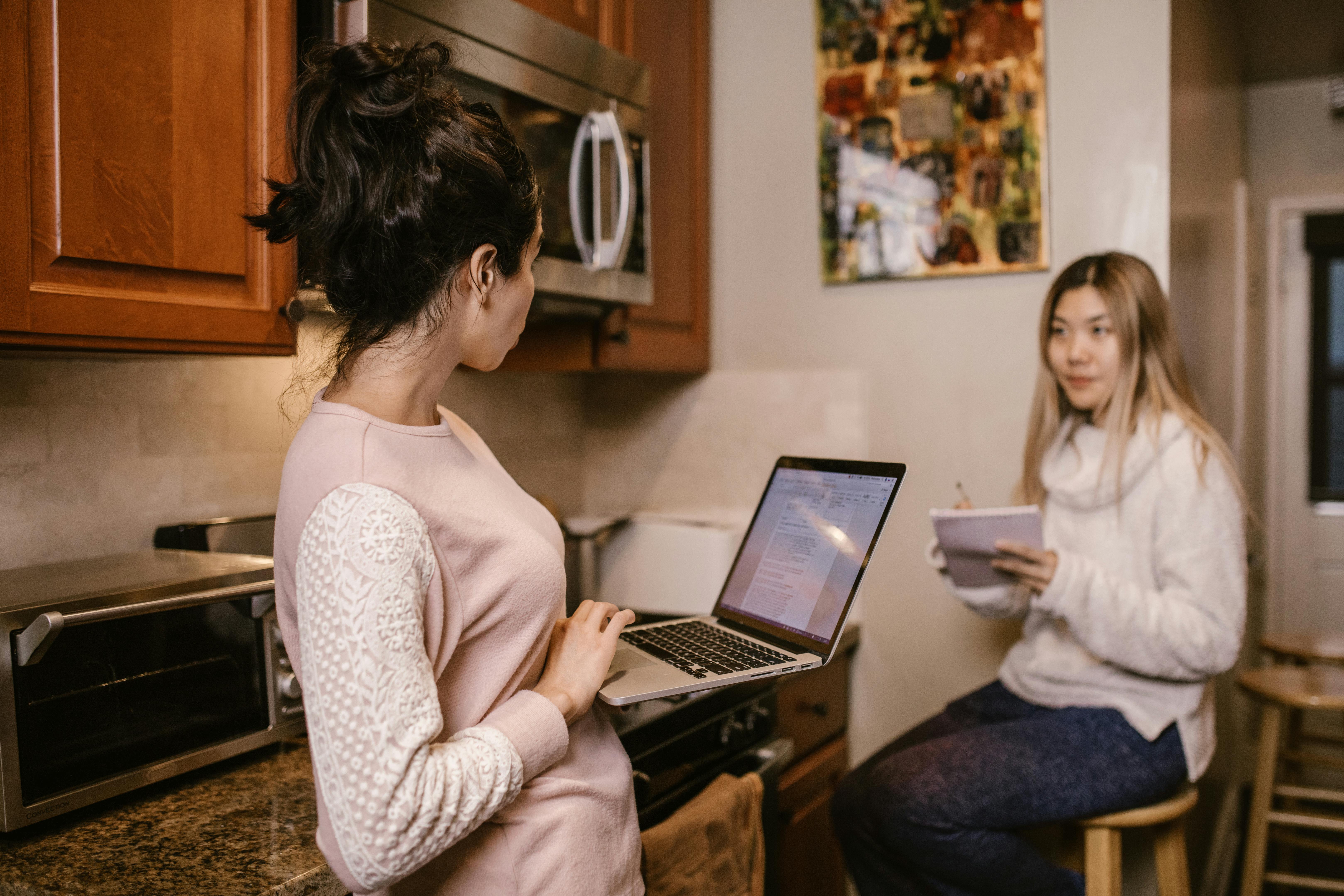 woman in white tank top using laptop computer