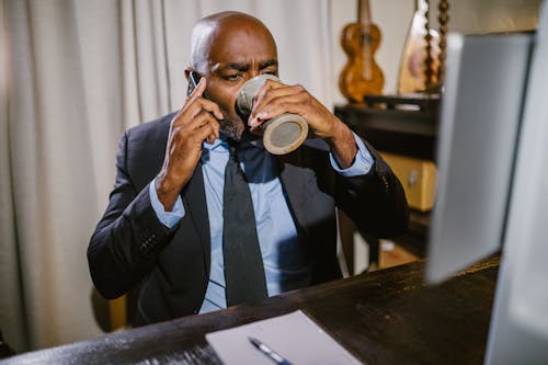 Free A Man Drinking while Talking on the Phone Stock Photo
