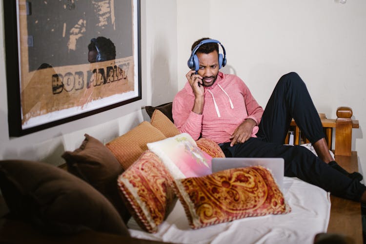 A Man Wearing Headphones While Talking On The Phone