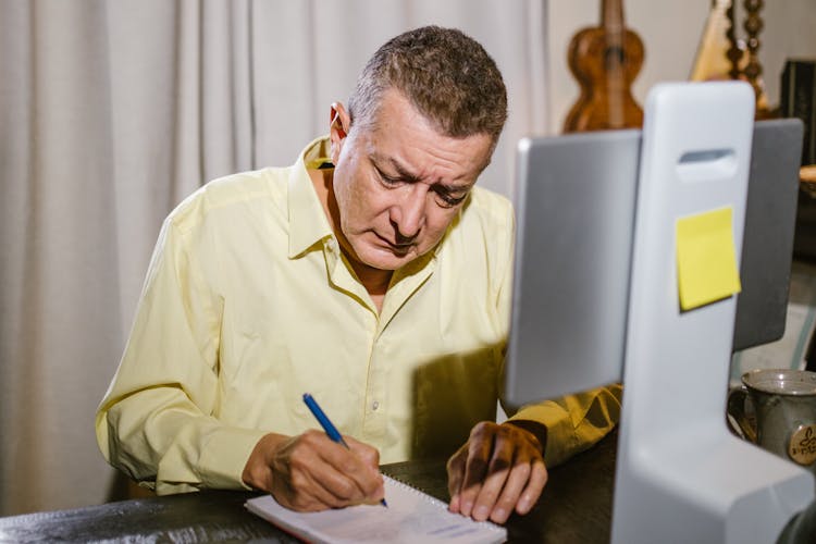 Man Writing On White Paper