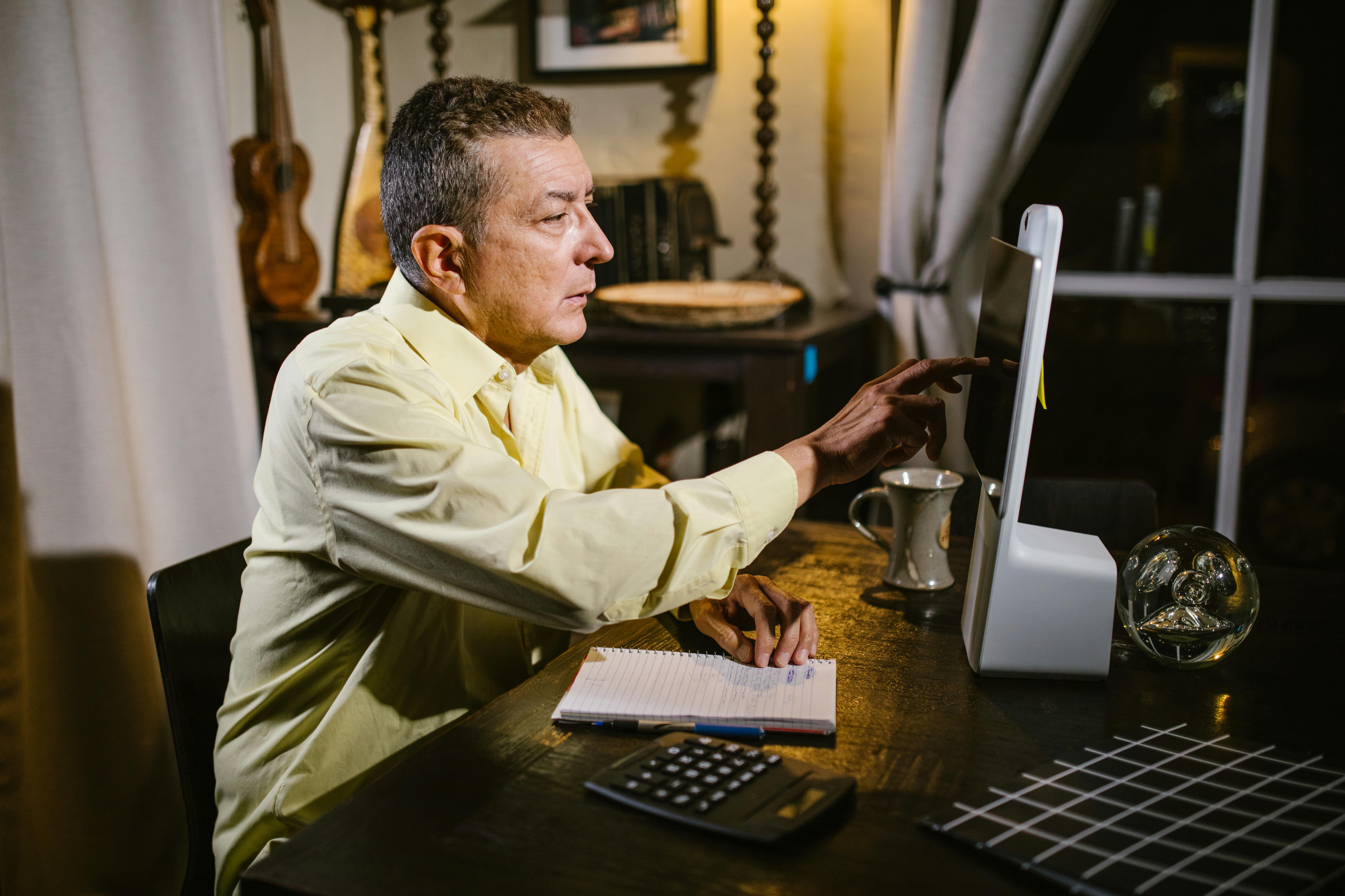 man touching screen of computer while sitting