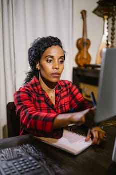 African American woman intensely working on a computer at home.