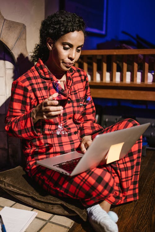 Free Woman Holding a Glass of Wine Using Laptop  Stock Photo