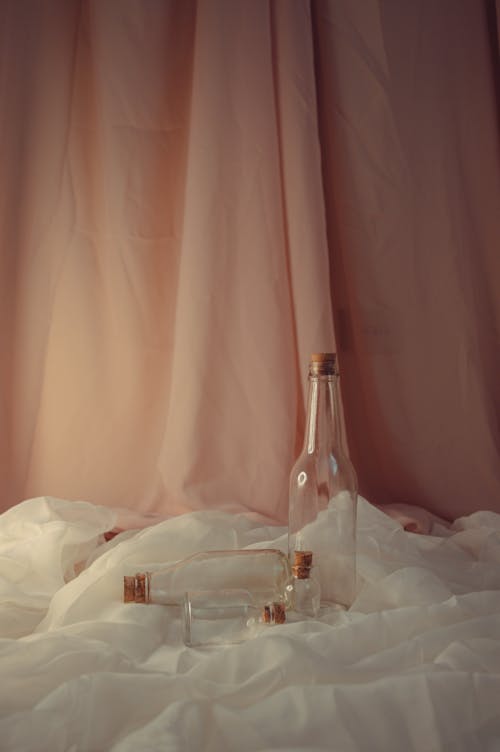 Immagine gratuita di bottiglie di vetro, natura morta, tenda rosa