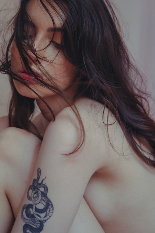 Topless Woman with Tattoo on Her Arm 