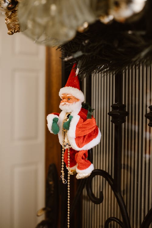 Santa Claus Figurine Hanging Near Metal Fence