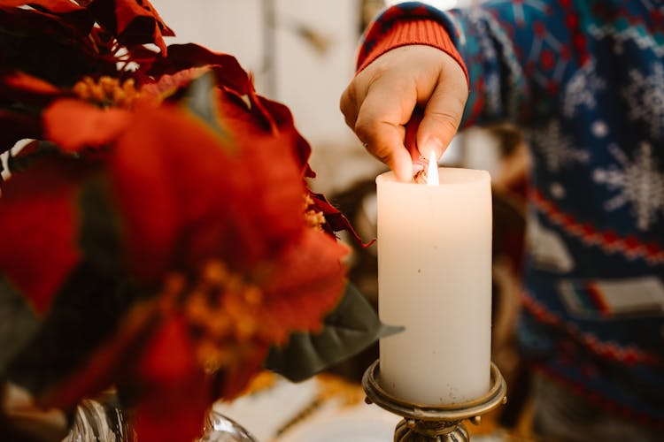 A Person Lighting A Candle