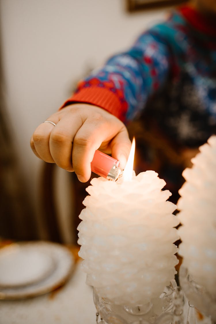 A Person Lighting A Candle