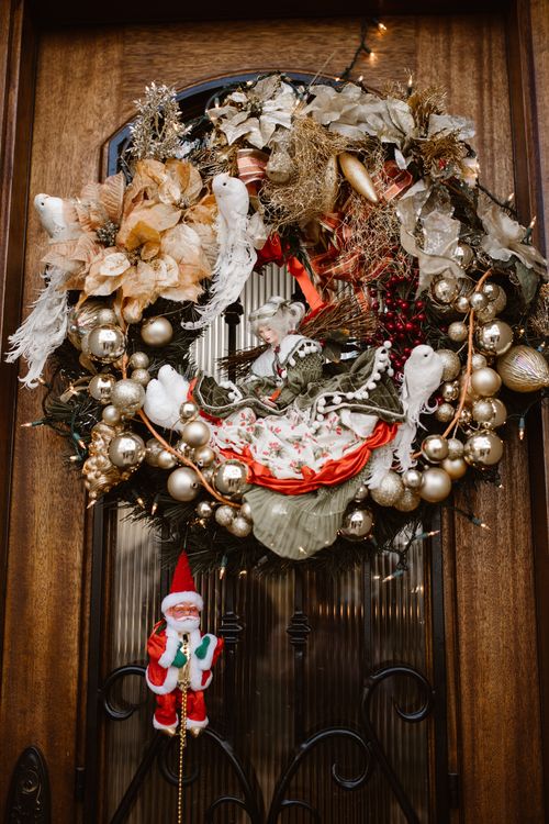 Free Elegant festive wreath with Santa and decorations on a wooden door, perfect for holiday cheer. Stock Photo