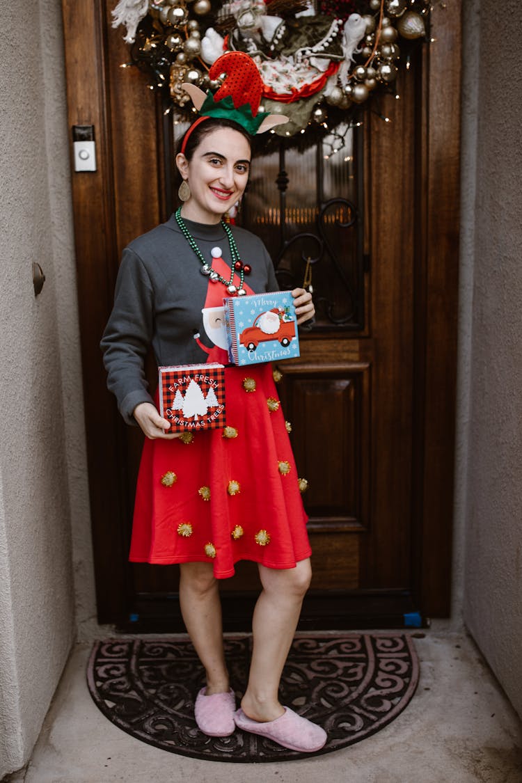 A Woman In A Festive Outfit Holding Christmas Presents