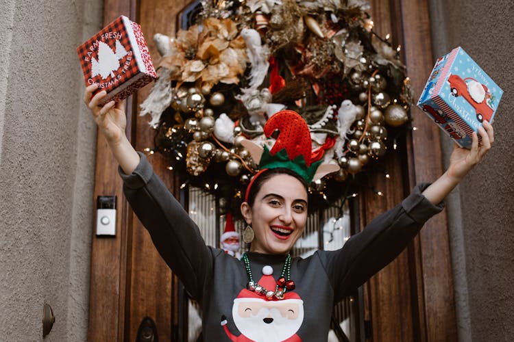 Woman Wearing Ugly Sweater And Holding Christmas Presents