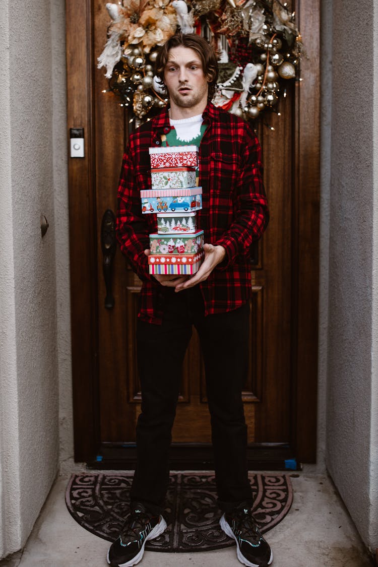 Man In Plaid Shirt Carrying A Stack Of Gifts