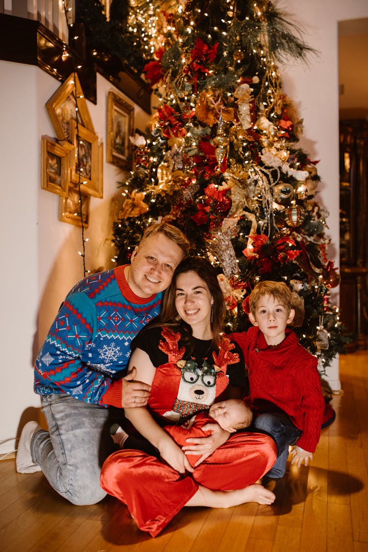 Family Posing Together Near A Christmas Tree