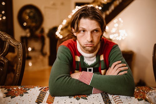 Free A Man in Red and Green Sweater Sitting on Chair Stock Photo