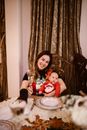 Happy Woman Sitting at Table with Her Baby