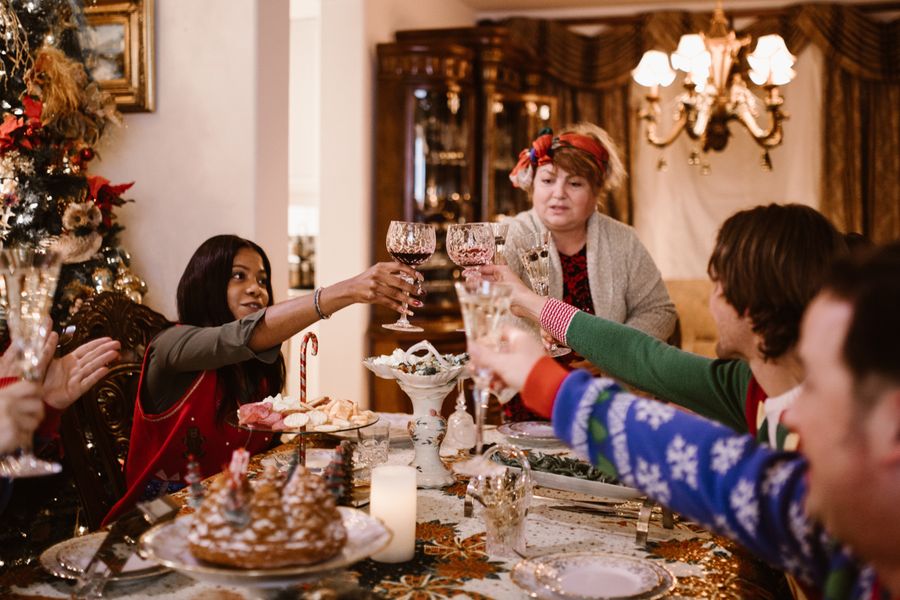 Famille trinquant avec des verres autour d'un repas de Noël