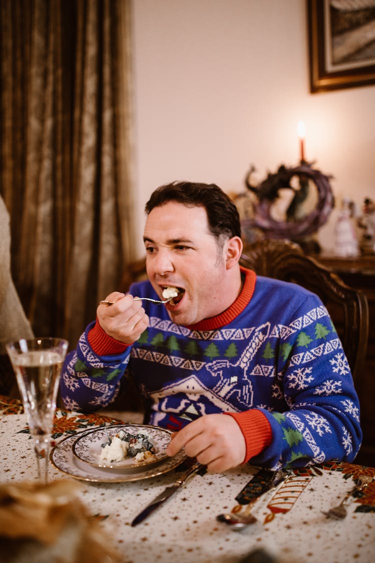 Man In Blue Christmas Sweater Eating Food