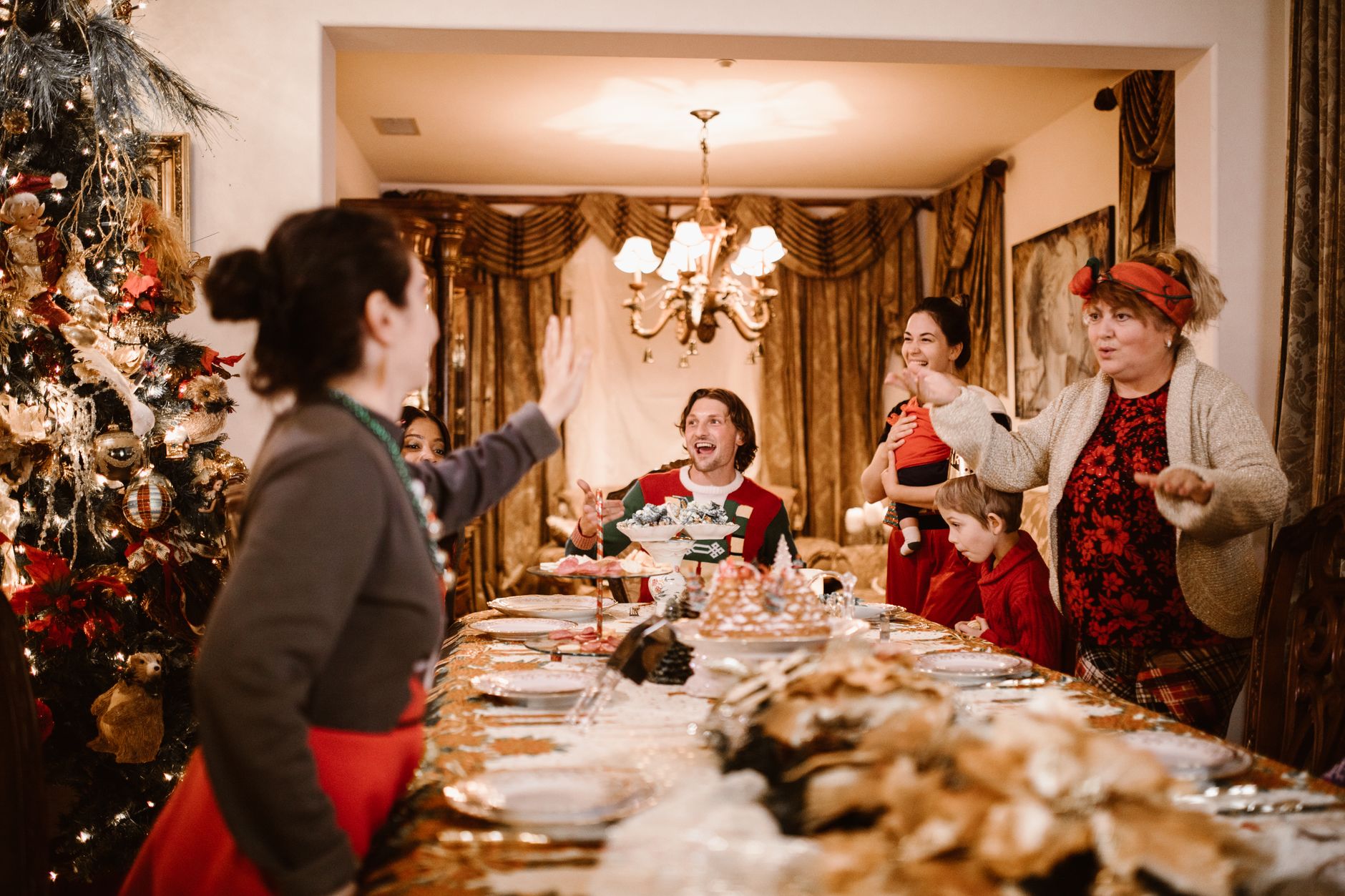 Family gathering around a festive dinner table celebrating Christmas with joy and laughter.