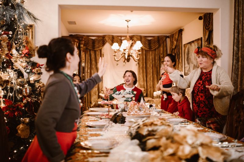 Family gathering around a festive dinner table celebrating Christmas with joy and laughter.
