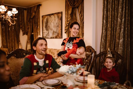 Family gathered indoors for a joyful holiday celebration with festive decorations.