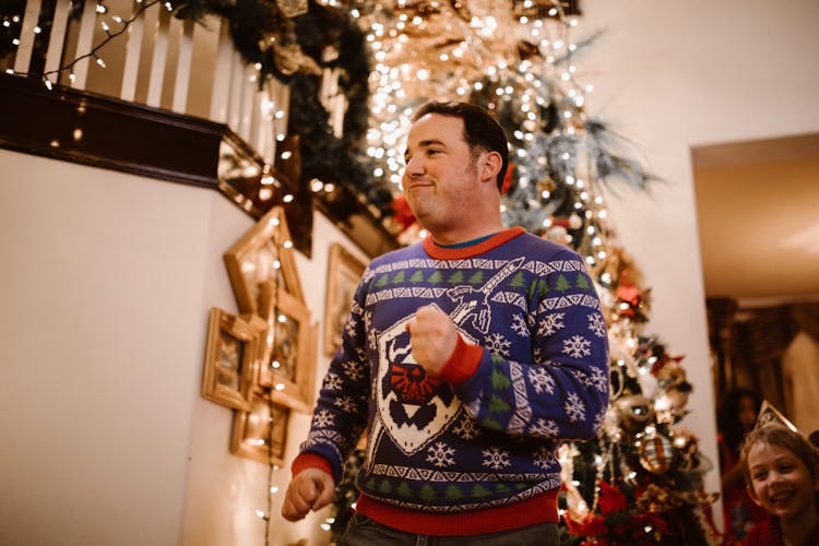 A Man Wearing A Blue Christmas Sweater