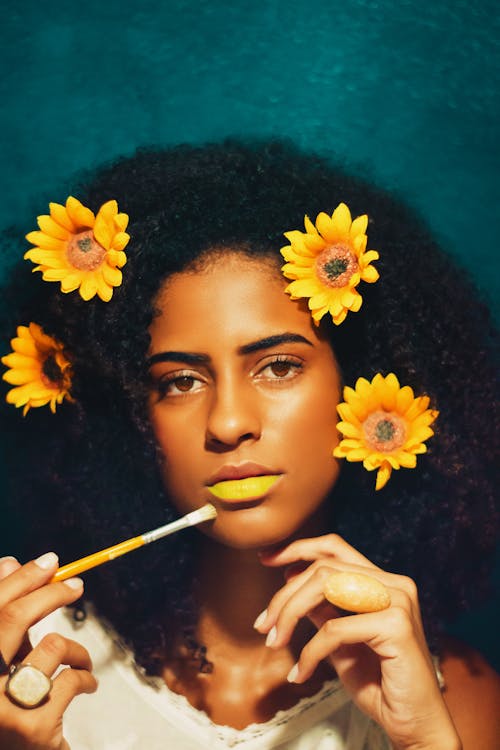 Young Woman with Flowers in Her Hair Painting Her Face