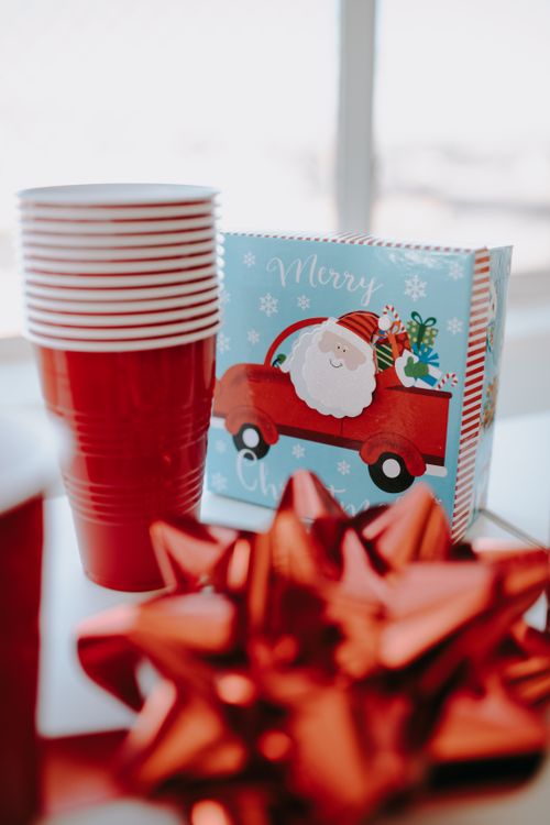 Free Bright Christmas-themed table setting with red accents and Santa illustration. Stock Photo