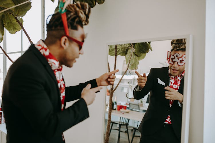 A Man In Black Suit Looking At The Mirror