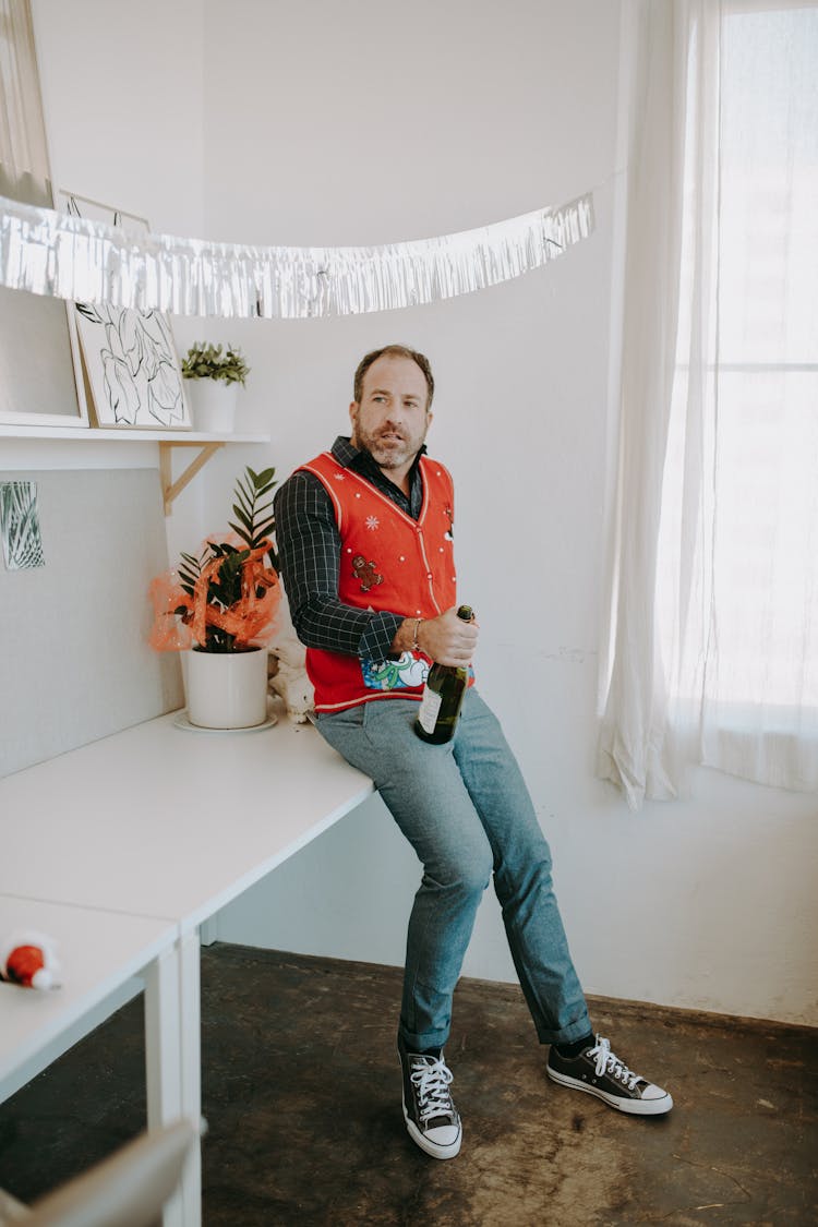 A Man Holding A Bottle Of Wine