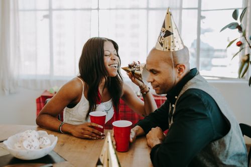 Free Two adults enjoy a New Year's party with drinks and laughter indoors. Stock Photo