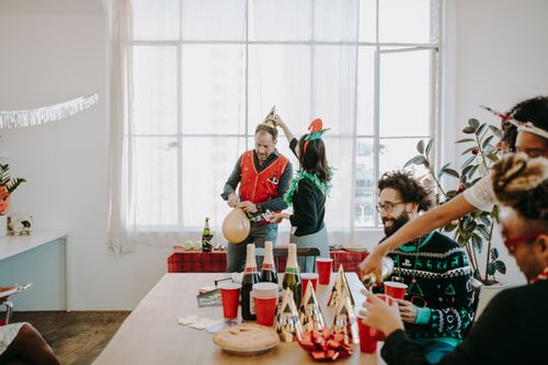 Free Festive office party with colleagues enjoying holiday cheer and decorations. Stock Photo
