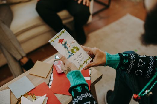 Cozy indoor holiday gathering featuring a person holding a festive card. Perfect for Christmas and office parties.