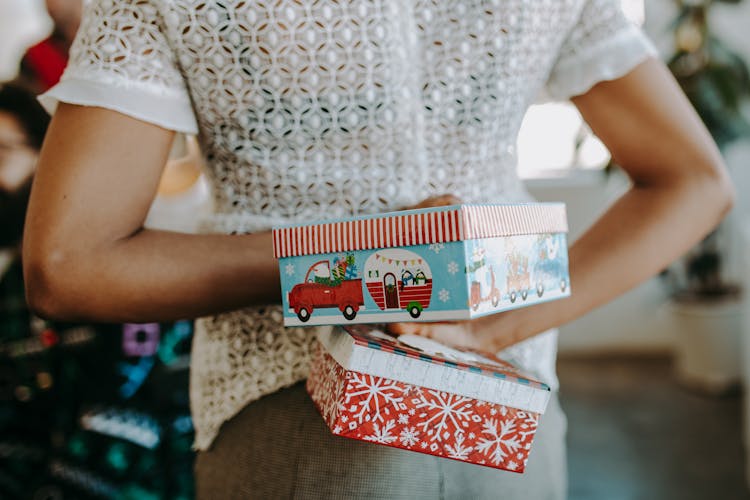 A Person Holding Green And Red Boxes On Her Back