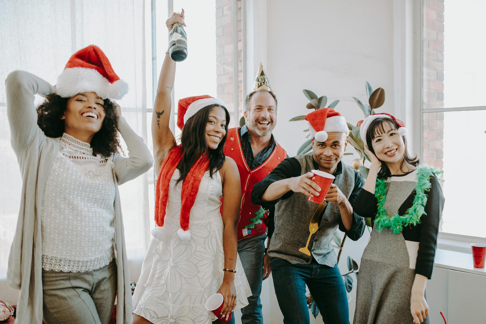 A group of people at an office party wearing various fun holiday accessories