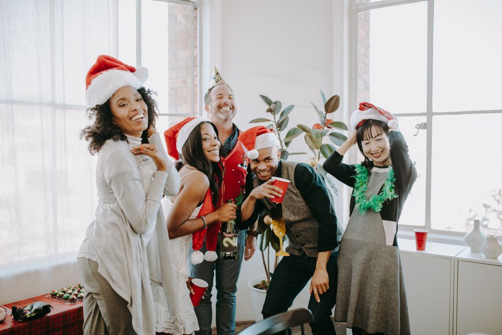 Friends celebrating at a Christmas party with festive hats