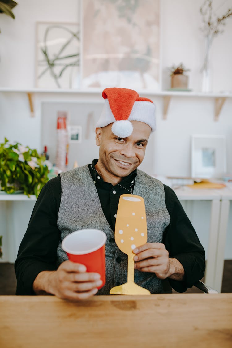 Man Wearing Santa Hat Holding A Plastic Cup