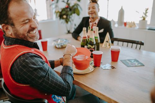 Free Two adults enjoying a festive celebration indoors, sharing smiles and laughter. Stock Photo