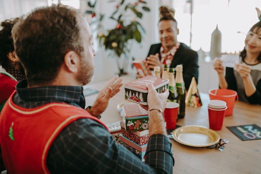 Enjoying a joyful holiday celebration at an office Christmas party with gift giving.