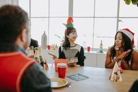 Colleagues at a holiday office party enjoying gifts and festive decorations.