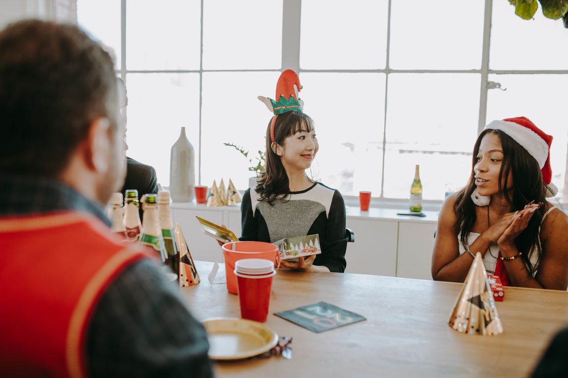 Colleagues enjoying gifts and festive decorations at a holiday office party