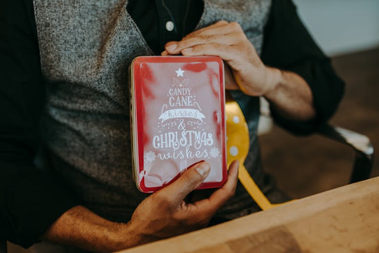 A Person Holding Red Box Of Candy Cane Candies