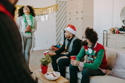 Free Festive office gathering with adults enjoying a Christmas party indoors. Stock Photo