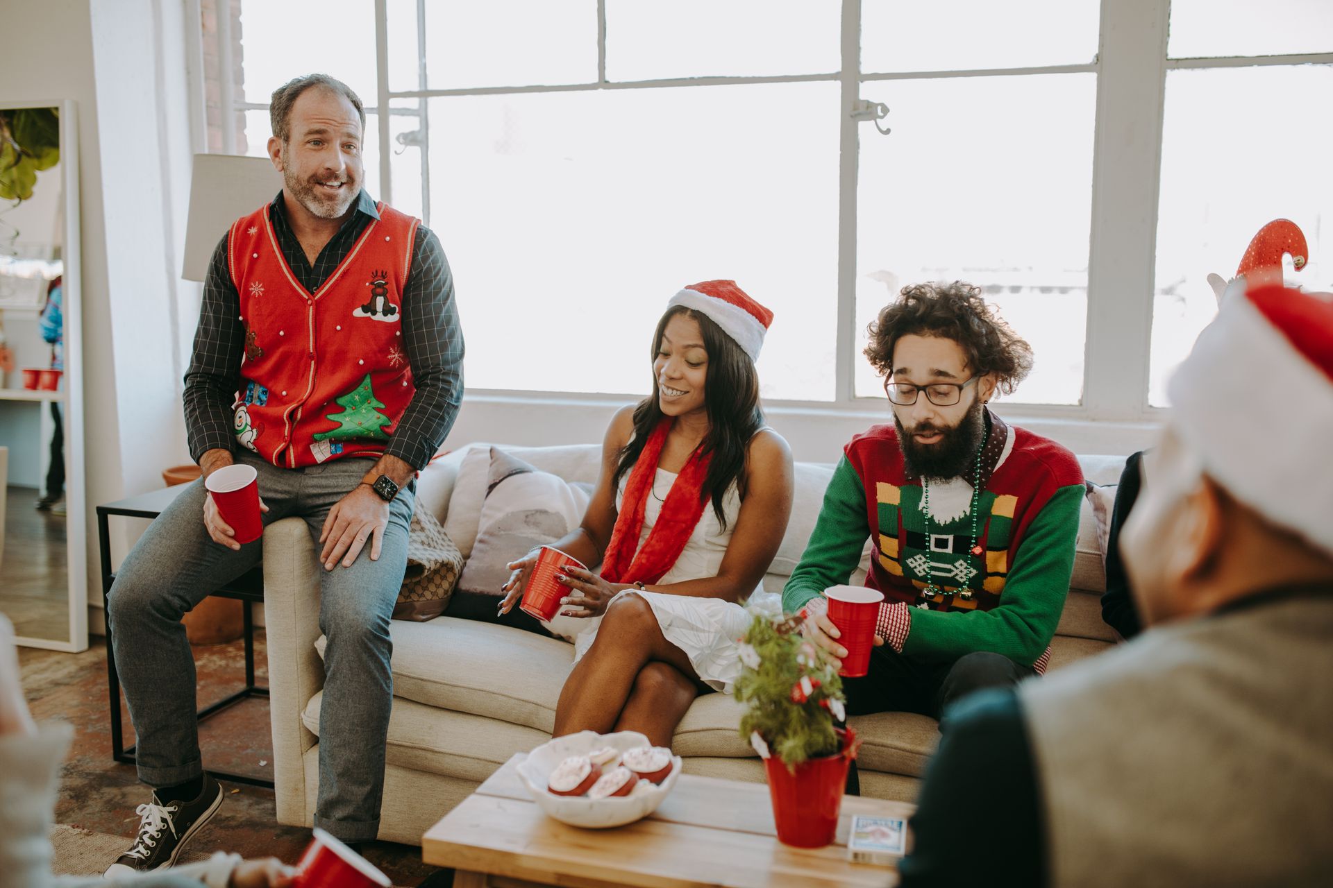 A group of colleagues enjoying a festive office Christmas party with holiday decor.