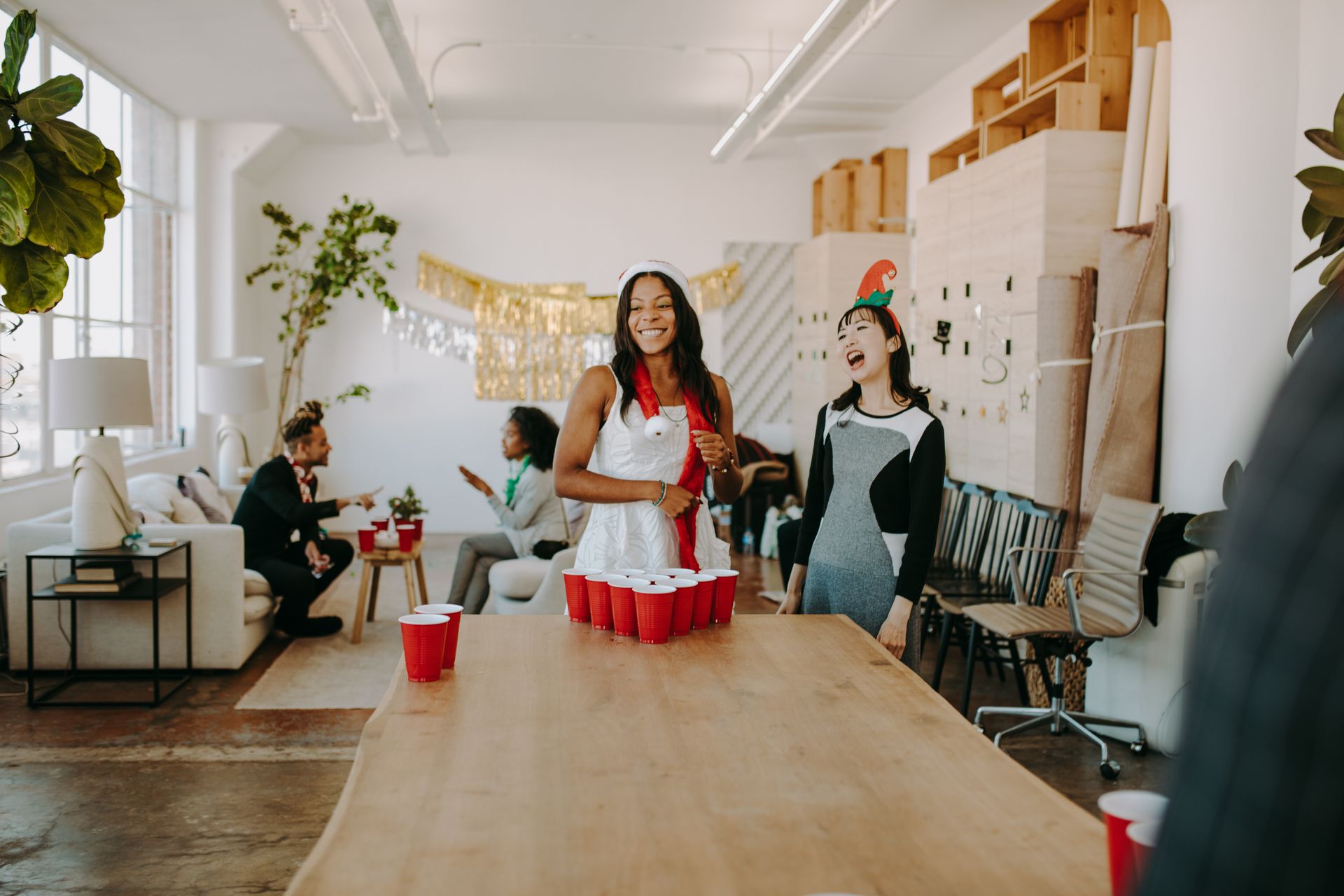 Lively office holiday party featuring beer pong, diverse team laughter, and festive decorations.